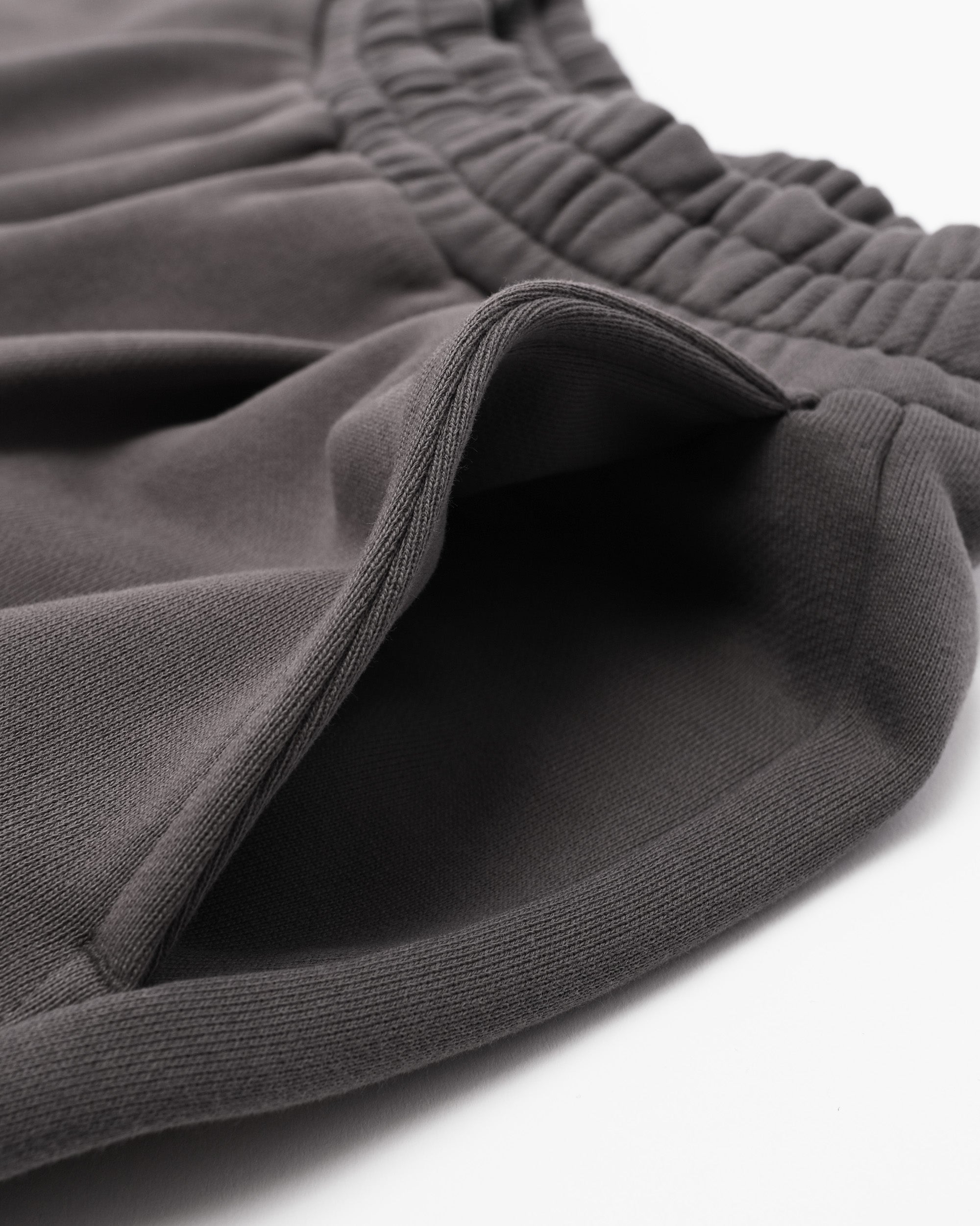 Close-up of gray sweatpants with a white background