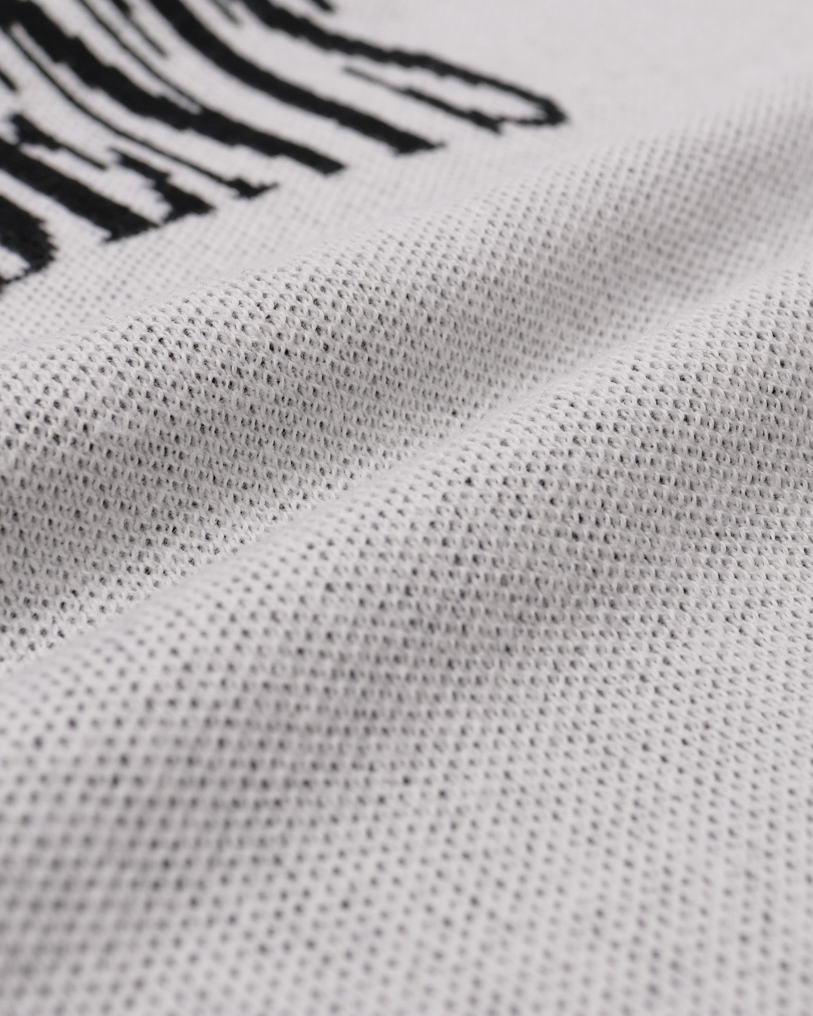 Close-up of a textured white fabric with black patterns