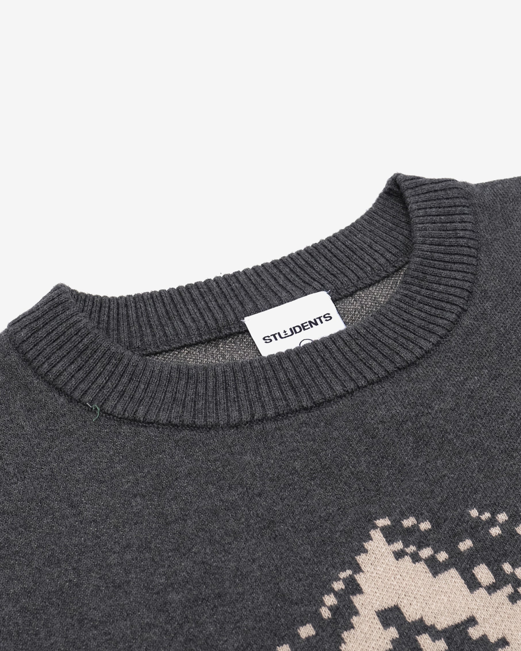 Close-up of a dark gray sweater with a patterned design and 'STUDIENZ' label on a light gray background