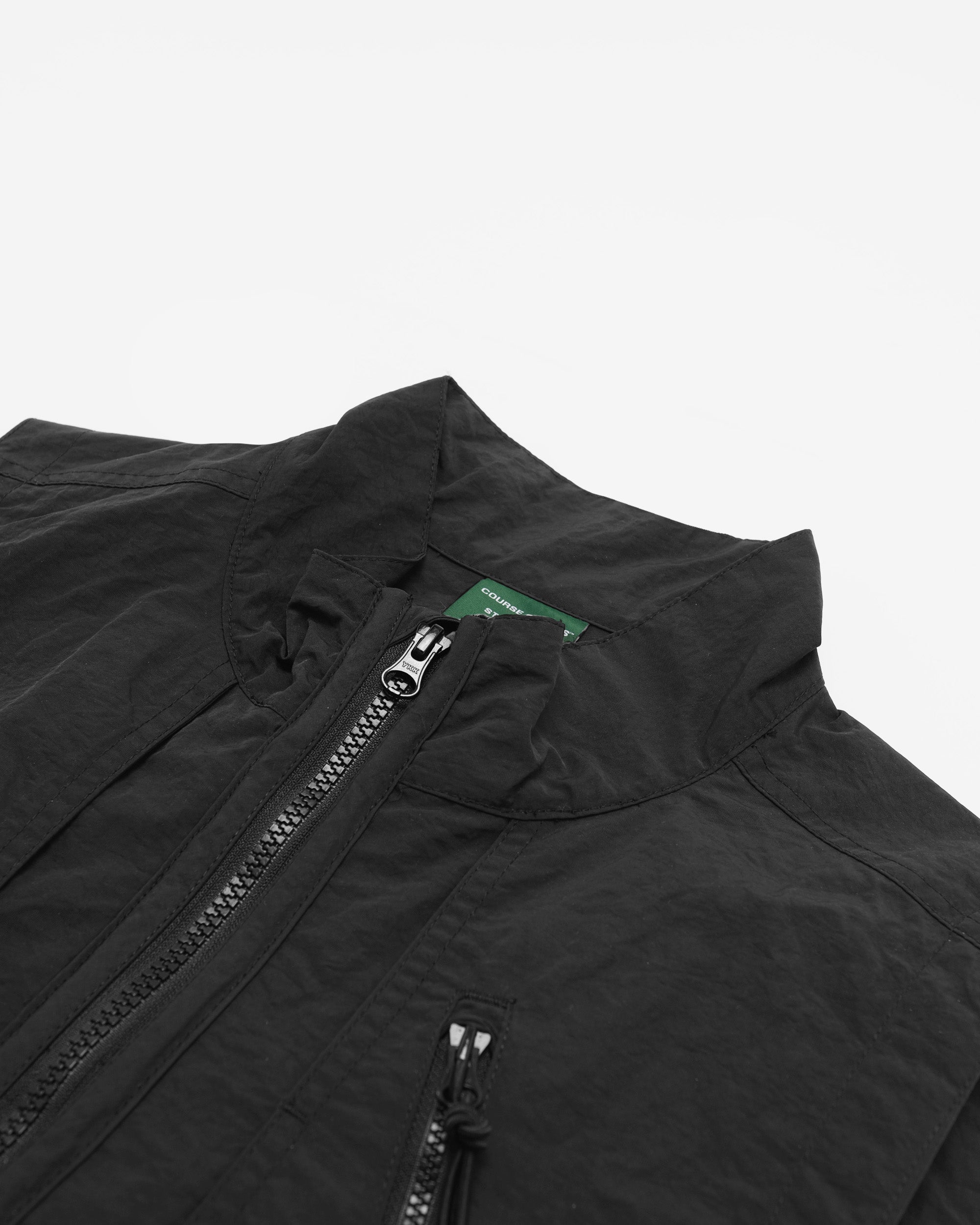 Close-up of a black jacket with a zipper on a light gray background