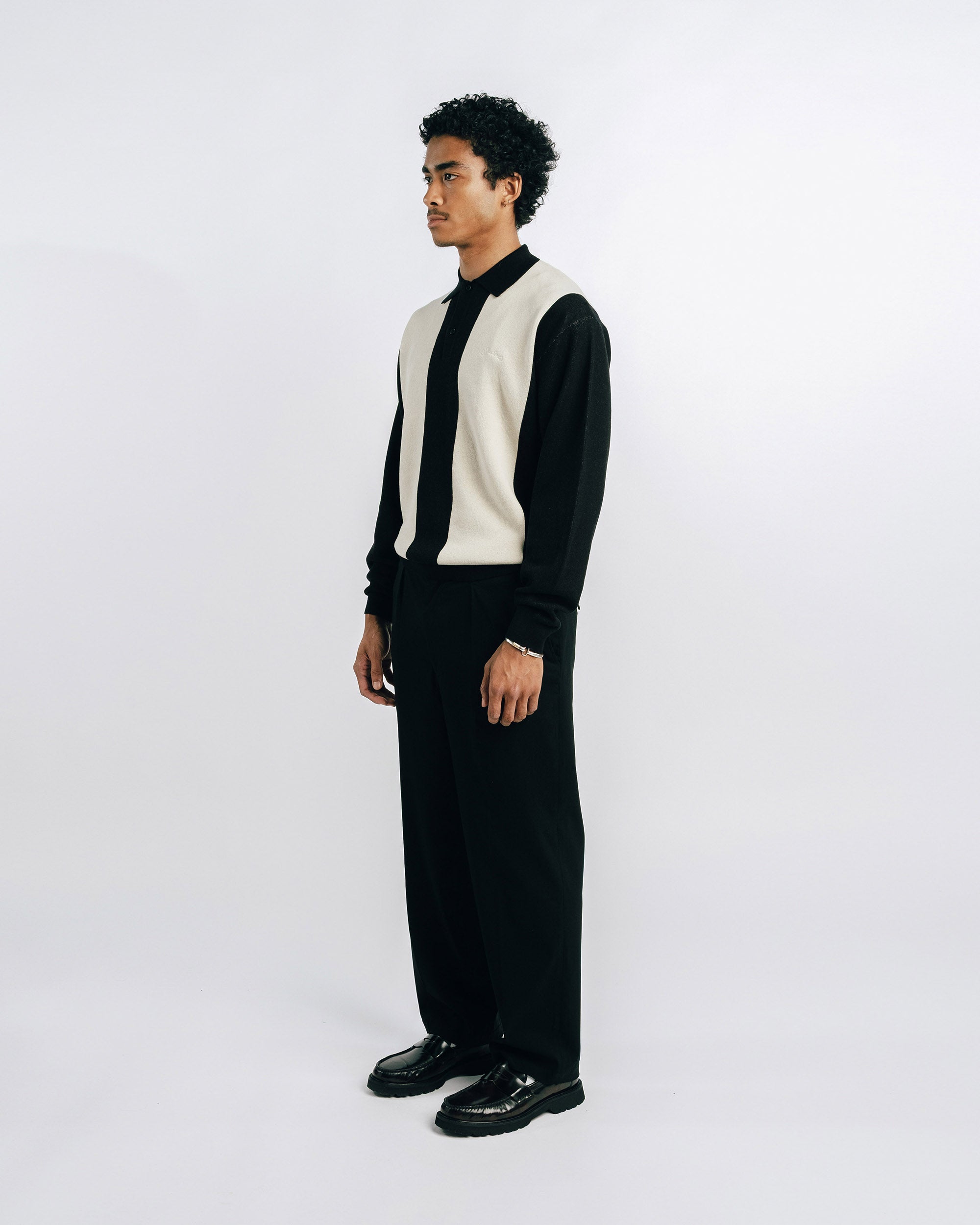 Person wearing a black and white outfit on a plain background