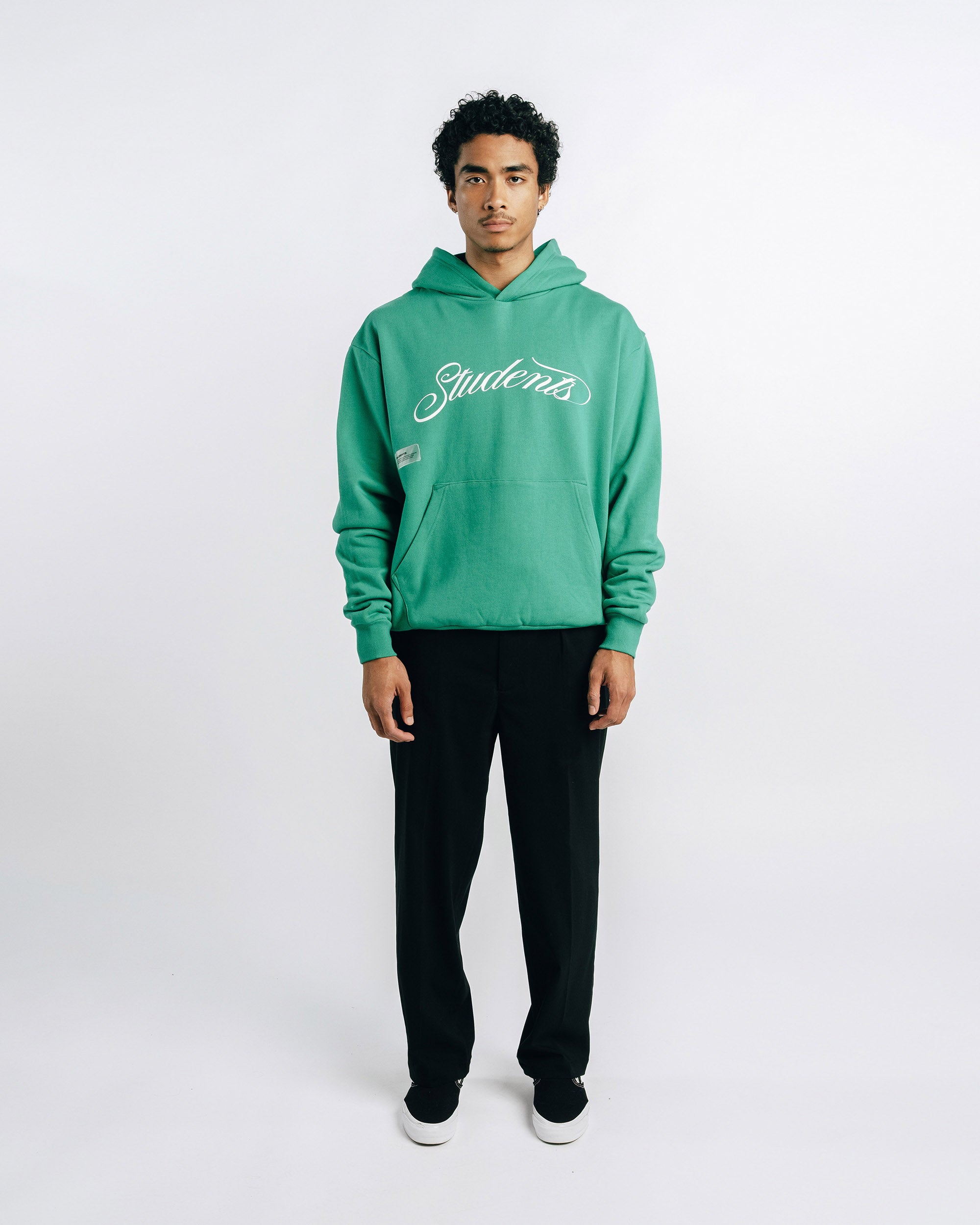 Person wearing a green hoodie with 'Students' text on a white background