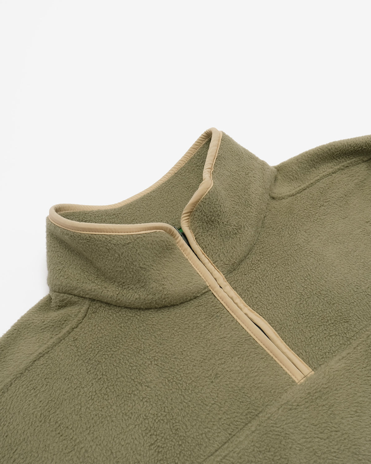 Close-up of a fleece pullover sweater in olive green with a beige zipper and matching beige piping along the stand collar, shown on a light gray background.