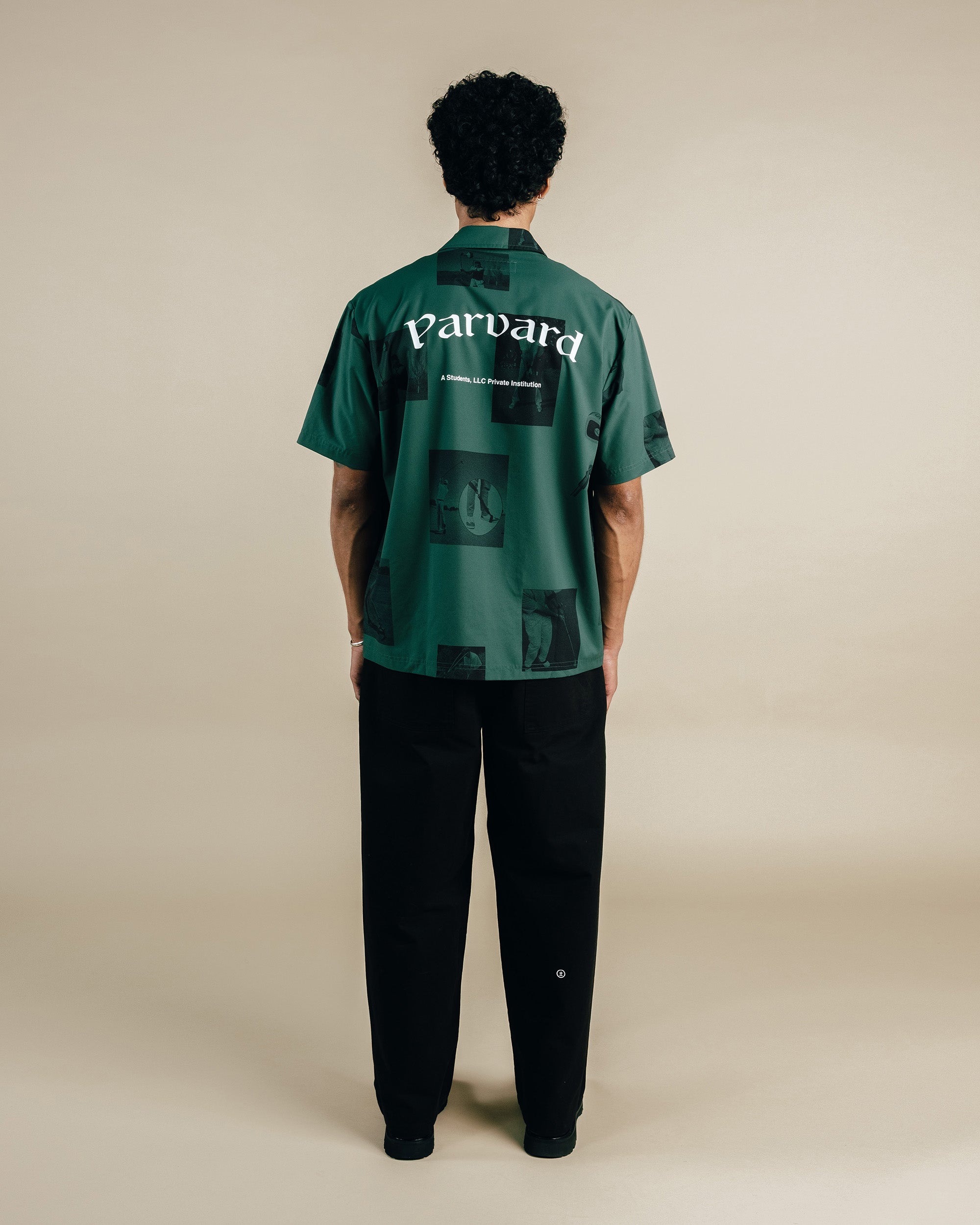 Person wearing a green shirt with 'Parvard' branding on the back, standing against a beige background.