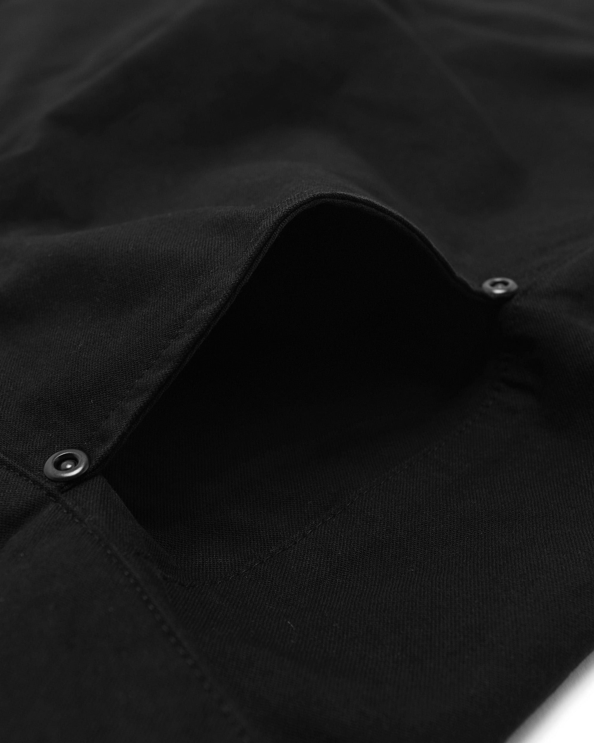 Close-up of a black pants with buttons on a dark background