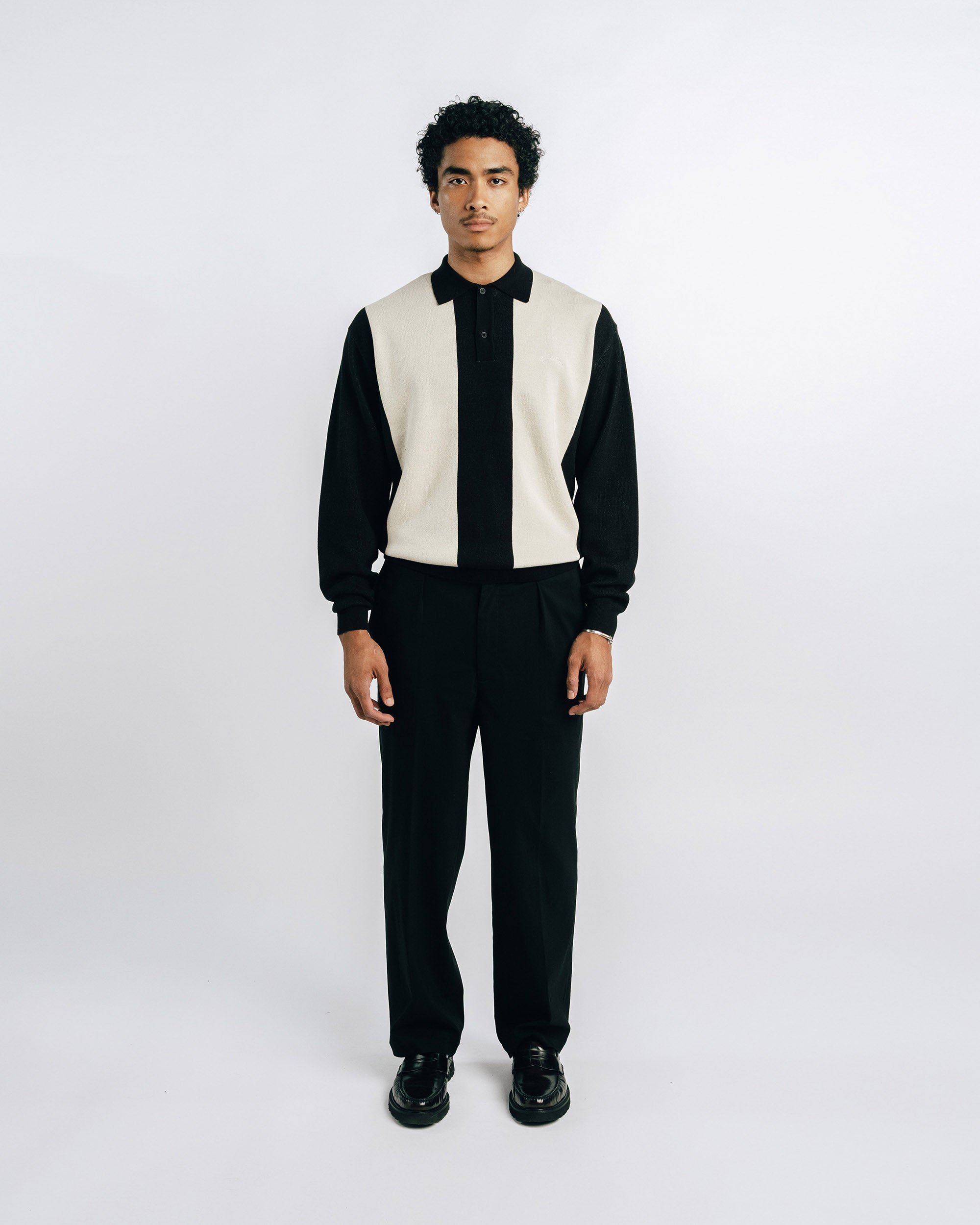 Man wearing a black suit with a white vest on a white background