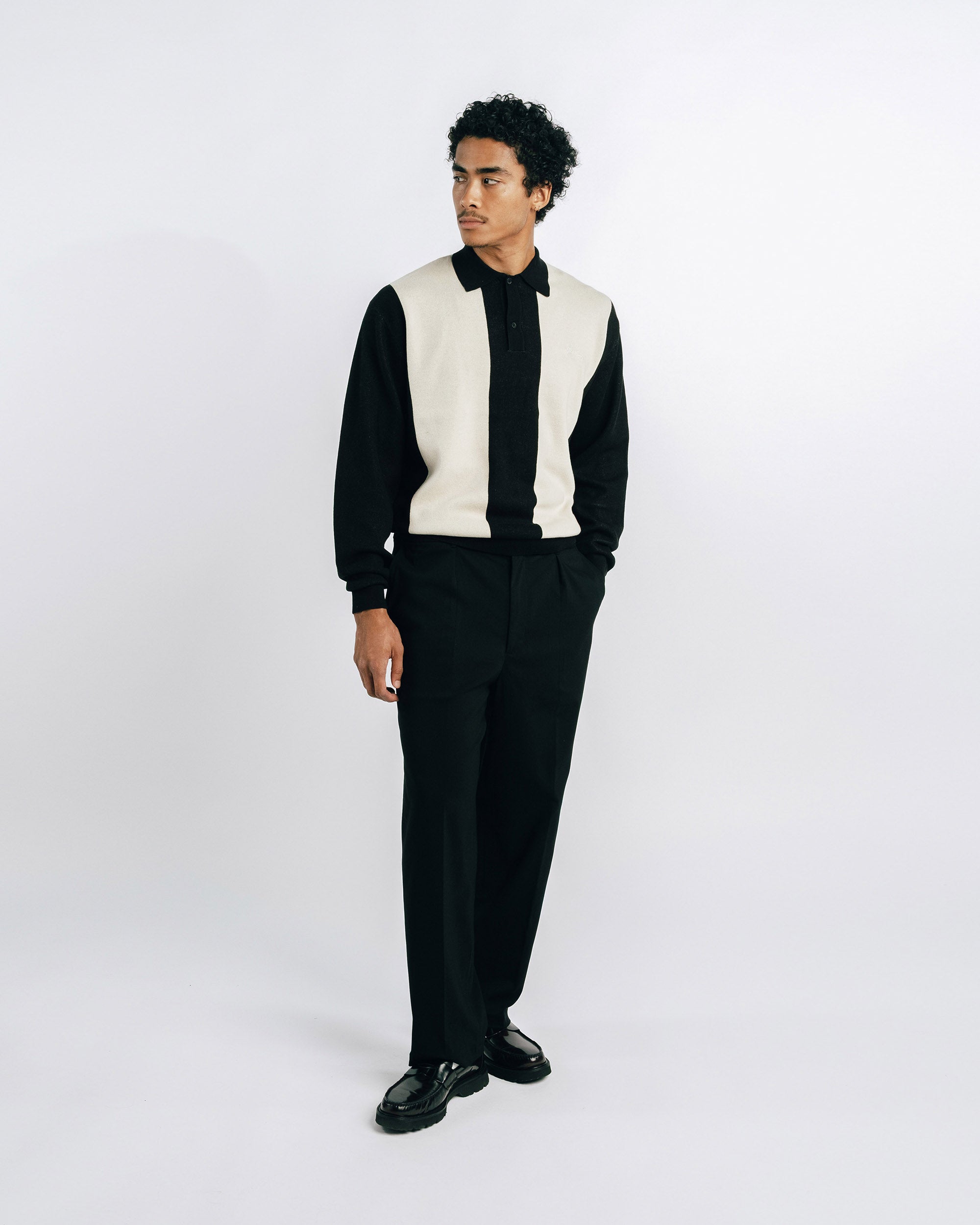 Man wearing a black suit with a white vest on a white background