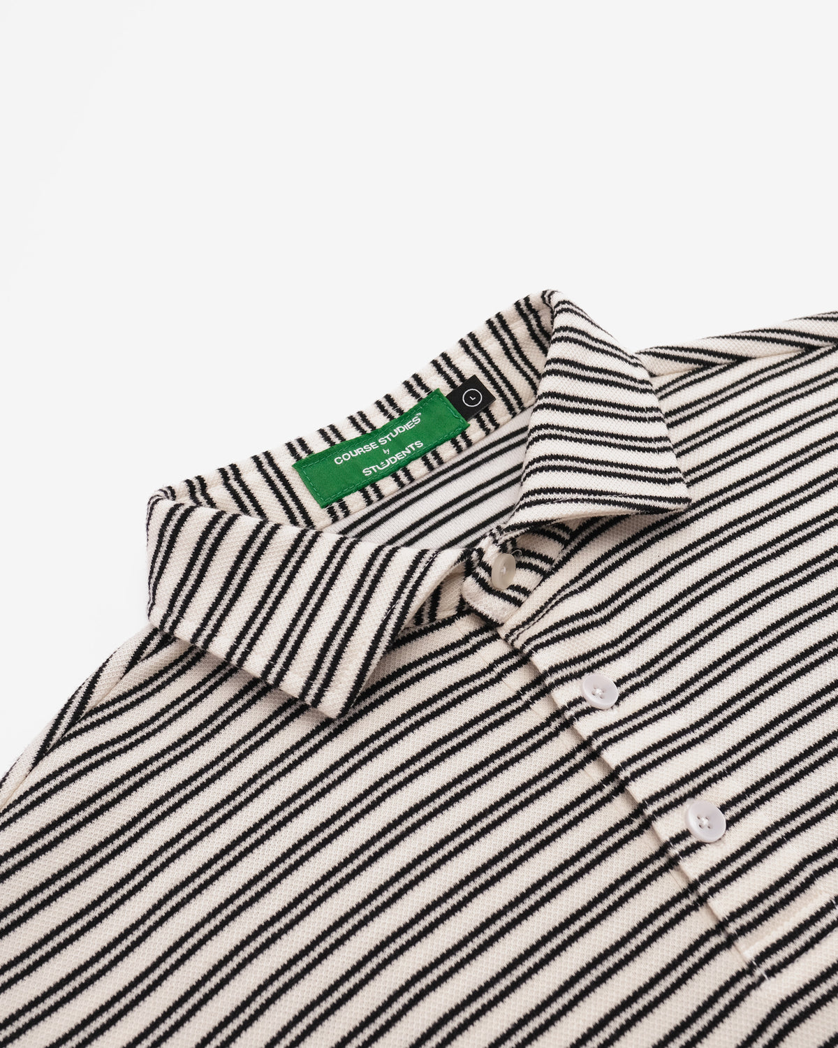 Close-up of a striped knit polo shirt collar with a green neck label reading 'pimkie fashion', on a light gray background.