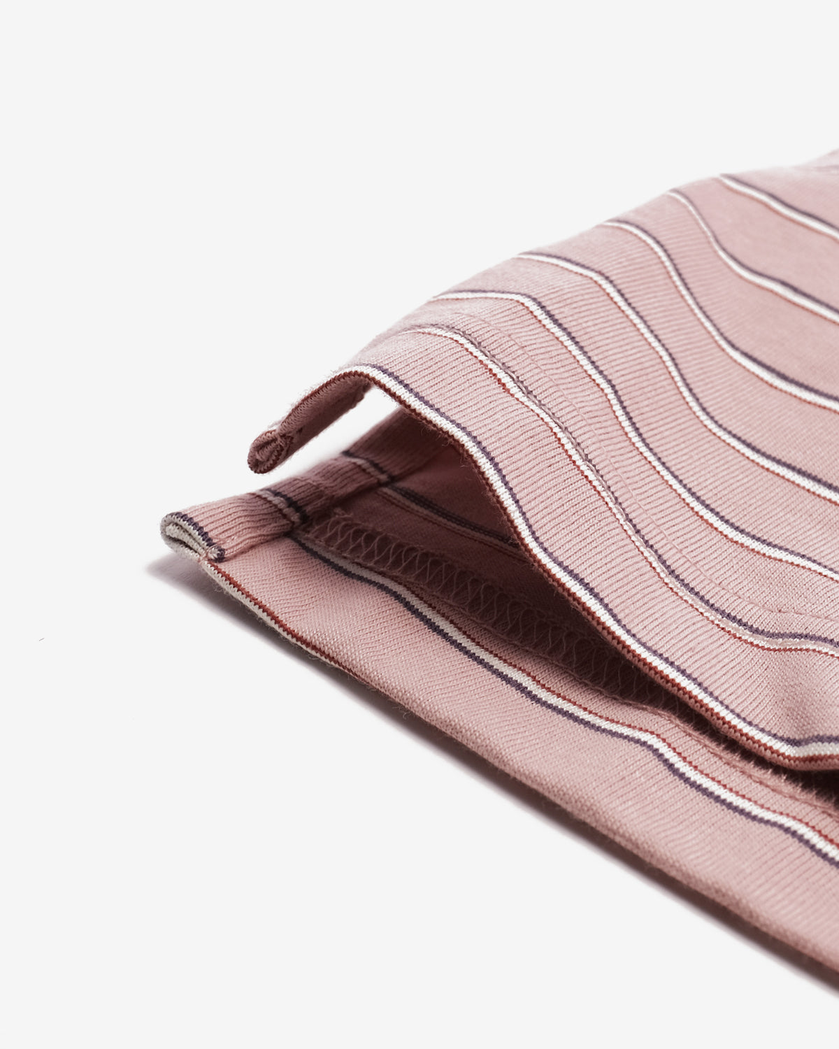 A close-up of a folded dusty pink striped fabric, likely a scarf or bandana, featuring thin white and navy blue pinstripes on a clean white background.